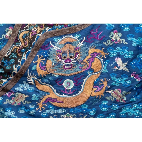 1063 - A Chinese gold thread embroidered blue-ground silk 'dragon' robe, 19th C.Dim.: 225 x 135 cm... 