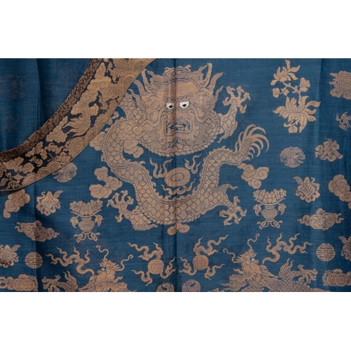 1064 - A Chinese embroidered silk blue-ground summer gauze 'nine dragons' robe, 19th C.Dim.: 215 x 130 cm... 