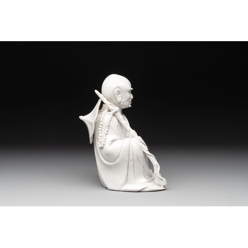 171 - A Chinese Dehua blanc de Chine Luohan on wooden stand, 19/20th C.H.: 21,5 cm (incl. stand)H.: 19 cm ... 