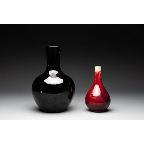 190 - A Chinese black-glazed 'tianqiu ping' vase and a flambe-glazed bottle vase, 19/20th C.H.: 32,4 cm (t... 