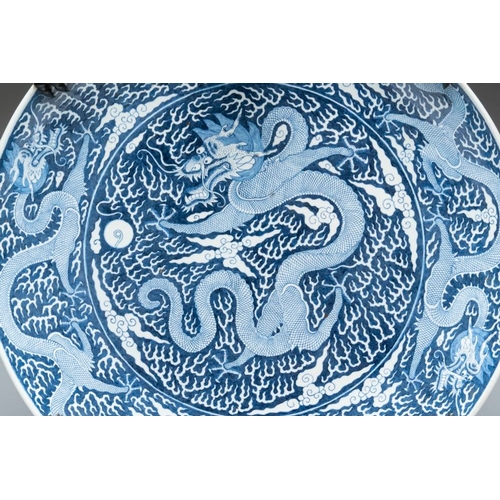 256 - A massive Chinese blue and white reverse-decorated  'dragon' charger with bronze mounts, Chuxiu Gong... 