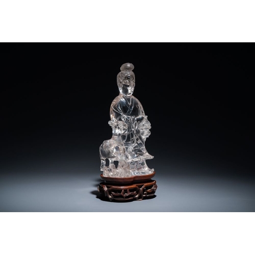 711 - A Chinese rock crystal sculpture of Lan Caihe on wooden stand, 19th C.H.: 32 cm (incl. stand)H.: 27 ... 