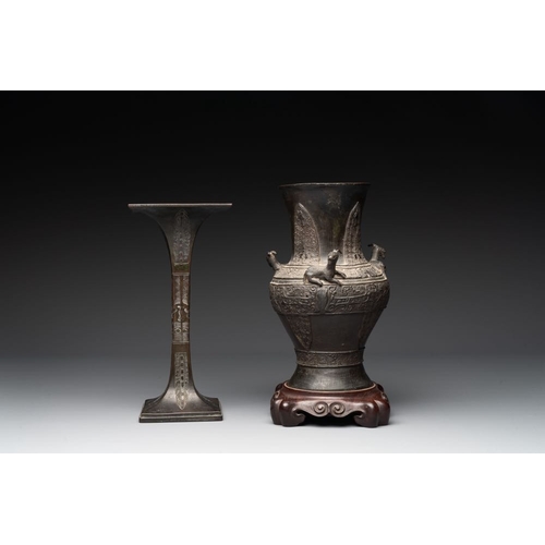 762 - A Chinese archaistic bronze 'gu' vase and a 'hu' vase with rams in relief on a wooden stand, 18/19th... 