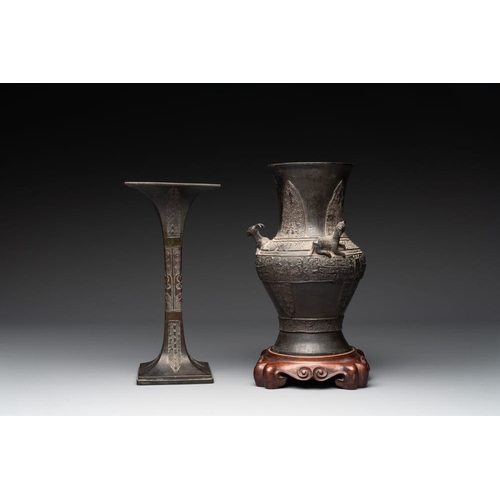 762 - A Chinese archaistic bronze 'gu' vase and a 'hu' vase with rams in relief on a wooden stand, 18/19th... 