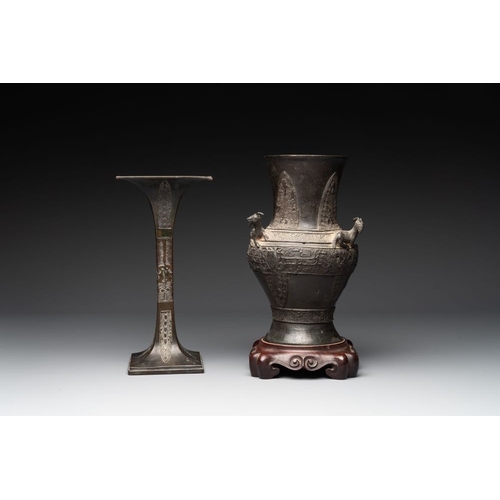 762 - A Chinese archaistic bronze 'gu' vase and a 'hu' vase with rams in relief on a wooden stand, 18/19th... 