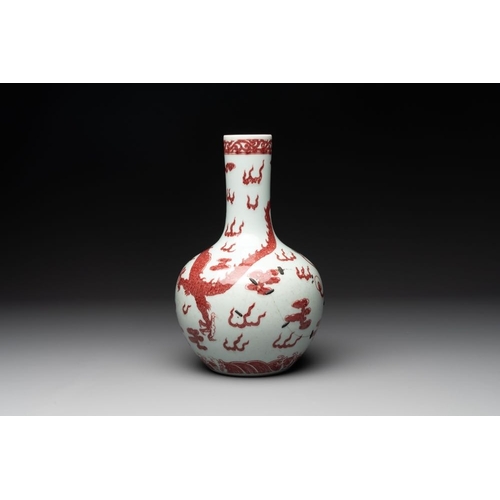 870 - A Chinese copper-red and white 'dragon' bottle vase, 18th C.H.: 30 cm