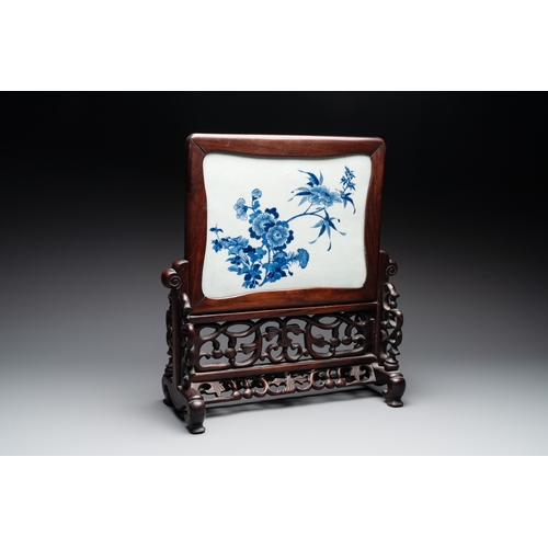 553 - A Chinese blue and white plaque with floral design in a carved wooden screen, 19/20th C.H.: 47 cm (i... 