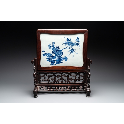 553 - A Chinese blue and white plaque with floral design in a carved wooden screen, 19/20th C.H.: 47 cm (i... 