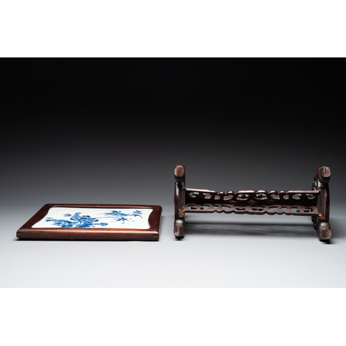 553 - A Chinese blue and white plaque with floral design in a carved wooden screen, 19/20th C.H.: 47 cm (i... 