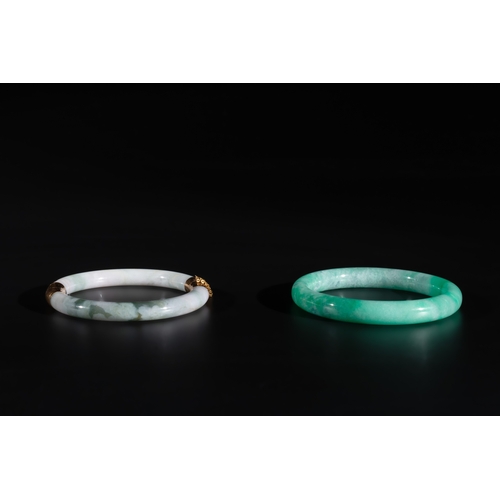 744 - Two Chinese jadeite bracelets, one with 14K gold mounts, 19/20th C.Dia.: 7,4 cm (the largest) Dia.: ... 