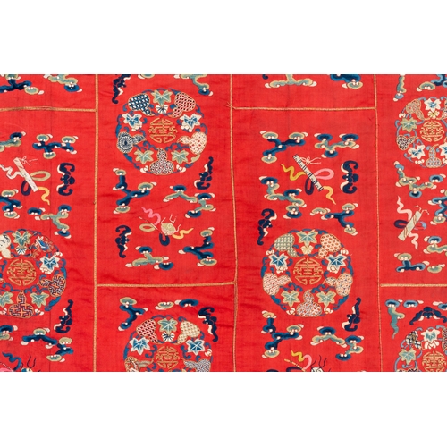 819 - A Chinese red-ground embroidered silk 'bajixiang' panel, Tie Shan Si mark, 19th C.Dim.: 253 x 122 cm... 