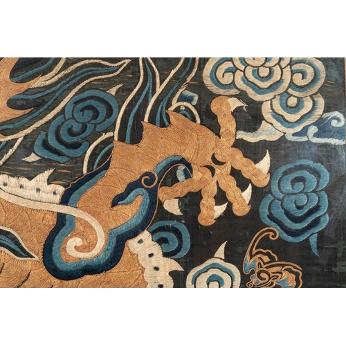 821 - A Chinese embroidered silk tapestry with a five-clawed dragon among clouds and bajixiang, 18/19th C.... 