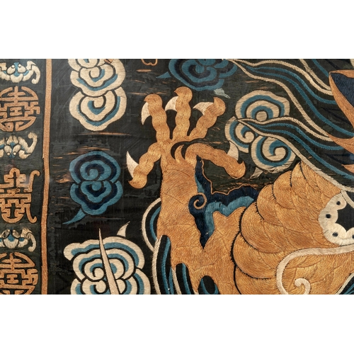 821 - A Chinese embroidered silk tapestry with a five-clawed dragon among clouds and bajixiang, 18/19th C.... 