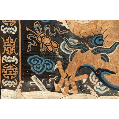 821 - A Chinese embroidered silk tapestry with a five-clawed dragon among clouds and bajixiang, 18/19th C.... 