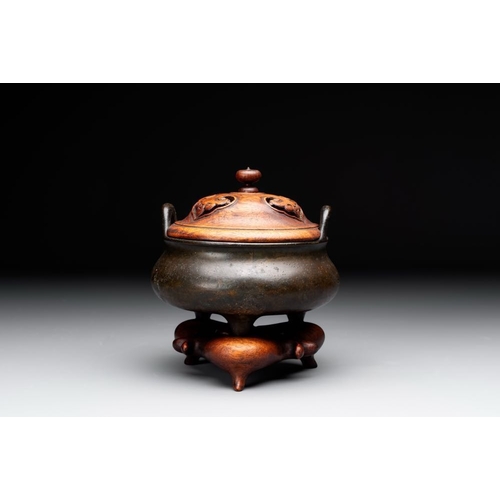 146 - A Chinese bronze tripod censer with wooden cover and stand, Xuande mark, 18/19th C.Dia.: 13,2 cm - H... 