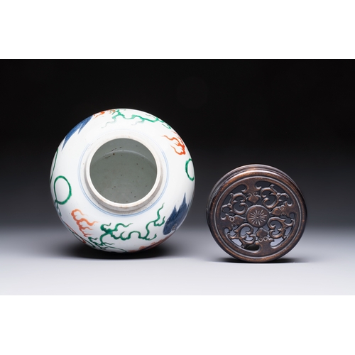 23 - A fine Chinese famille verte 'Buddhist Lions' jar and a reticulated wooden cover, 19th C.H.: 23,5 cm... 