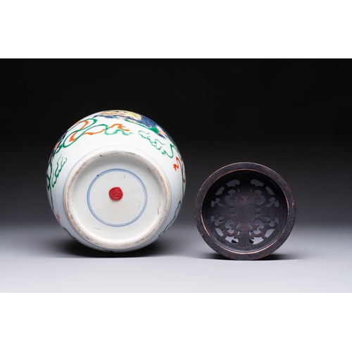 23 - A fine Chinese famille verte 'Buddhist Lions' jar and a reticulated wooden cover, 19th C.H.: 23,5 cm... 