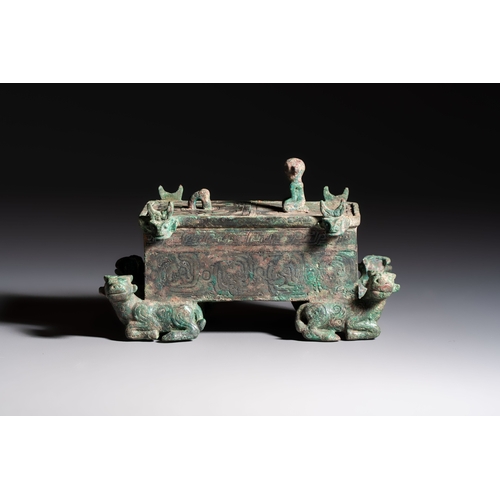 242 - A Chinese archaic bronze cosmetic box standing on four stylised buffalo-form feet, Lian, Eastern Zho... 