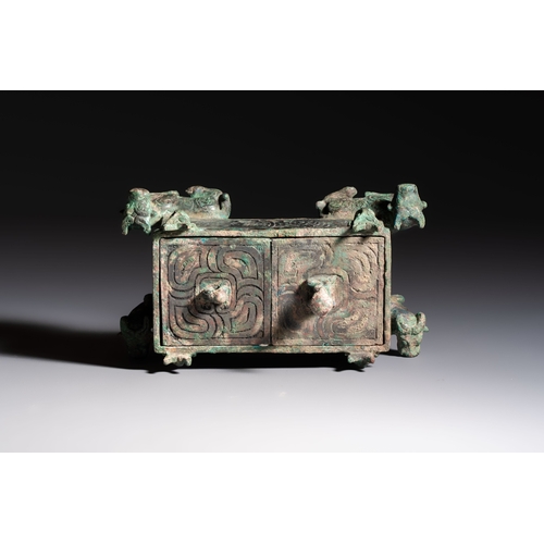 242 - A Chinese archaic bronze cosmetic box standing on four stylised buffalo-form feet, Lian, Eastern Zho... 