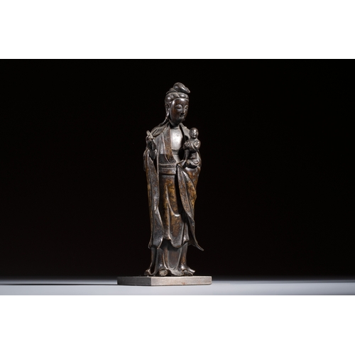 260 - A Chinese bronze standing Guanyin with boy, MingH.: 20,7 cm (incl. stand)H.: 19,7 cm (excl. stand)
W... 