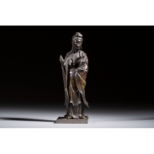 260 - A Chinese bronze standing Guanyin with boy, MingH.: 20,7 cm (incl. stand)H.: 19,7 cm (excl. stand)
W... 