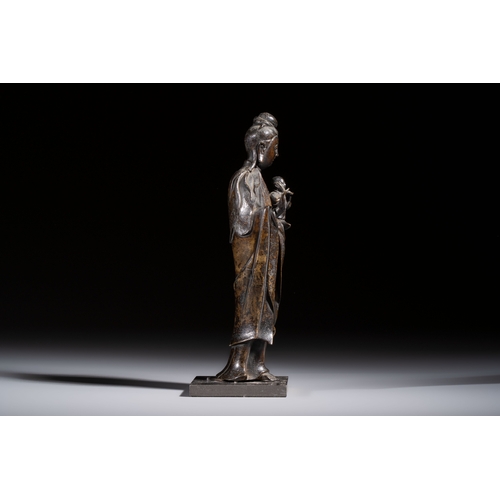 260 - A Chinese bronze standing Guanyin with boy, MingH.: 20,7 cm (incl. stand)H.: 19,7 cm (excl. stand)
W... 
