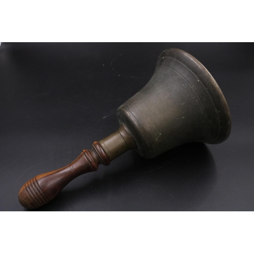 343 - A vintage handheld bell with with wooden handle. (11 inches)