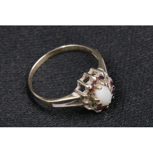 94 - 9 CT Gold Ladies Ring with an Opal Centre Stone with small red stones surrounding it, 1 missing. Ove... 