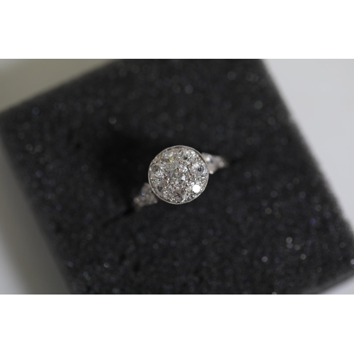 111 - A diamond cluster ring, with diamond shoulders, set in Platinum, ring size Q