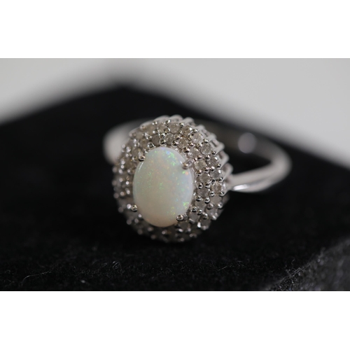 113 - An Oval white opal an diamond cluster ring, set in 9ct white gold, ring size O