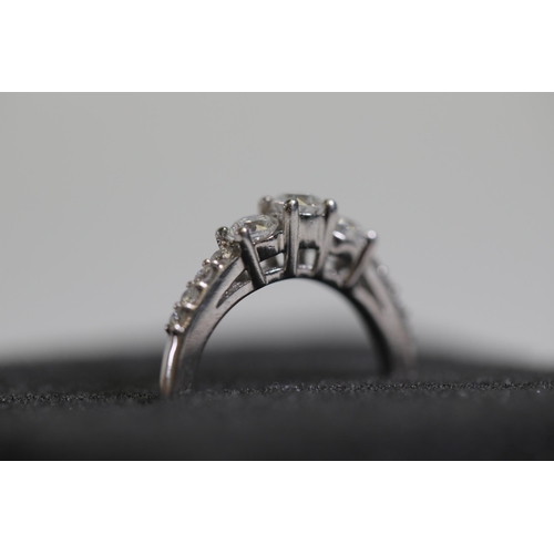 119 - A 3 stone diamond ring, cathedral set with diamond shoulders, set in platinum, ring size K-L