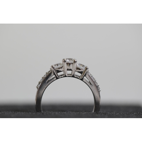 119 - A 3 stone diamond ring, cathedral set with diamond shoulders, set in platinum, ring size K-L