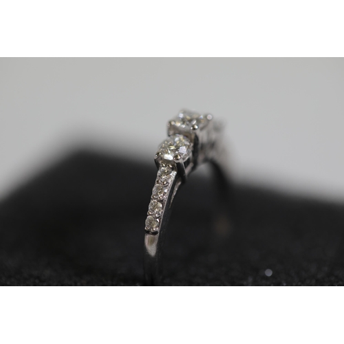 119 - A 3 stone diamond ring, cathedral set with diamond shoulders, set in platinum, ring size K-L