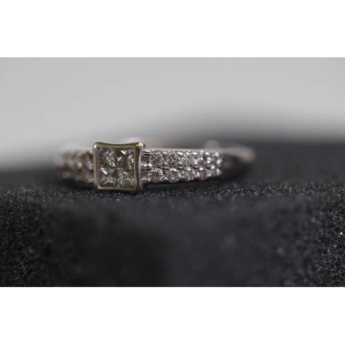 120 - A 4 stone diamond ring, in rub over setting with diamond shoulders. Set in 18ct white gold, ring siz... 