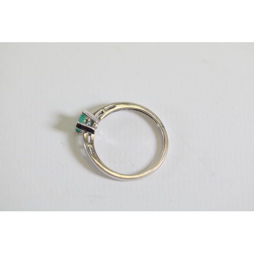 124 - An emerald solitaire ring with diamond shoulders, set in 9ct white gold, ring size O-P