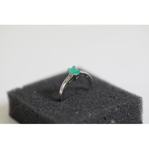 124 - An emerald solitaire ring with diamond shoulders, set in 9ct white gold, ring size O-P