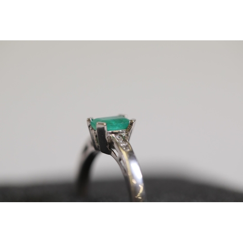 124 - An emerald solitaire ring with diamond shoulders, set in 9ct white gold, ring size O-P