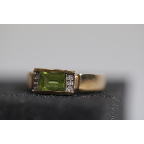 187 - Emerald Cut peridot with diamond shoulders in 9ct yellow gold between O and P