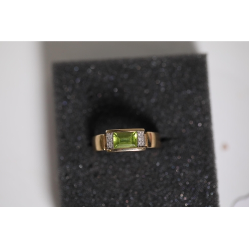 187 - Emerald Cut peridot with diamond shoulders in 9ct yellow gold between O and P