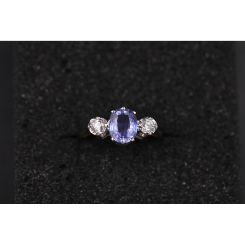 34 - Oval Sapphire and twin diamond ring set 18ct yellow gold Ring size is half way between N and O