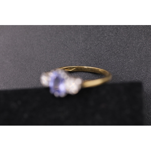 34 - Oval Sapphire and twin diamond ring set 18ct yellow gold Ring size is half way between N and O