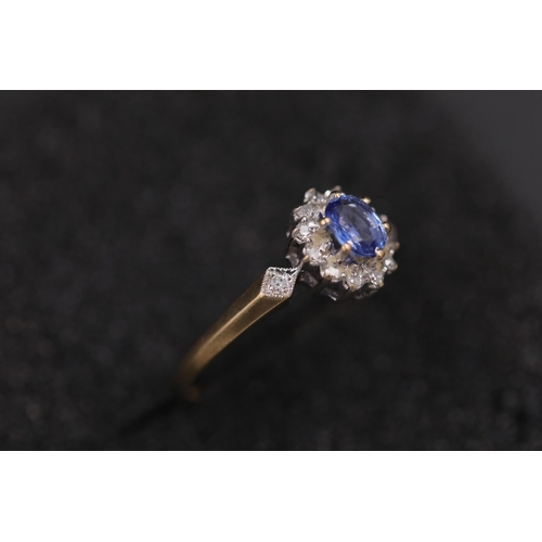 37 - Oval sapphire in diamond cluster set in 9ct yellow gold with diamond shoulders Ring size between N a... 