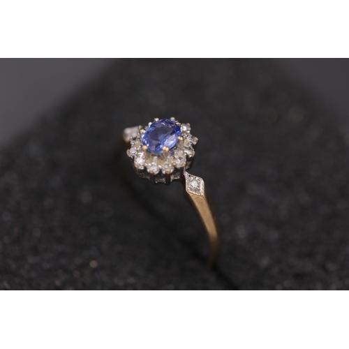 37 - Oval sapphire in diamond cluster set in 9ct yellow gold with diamond shoulders Ring size between N a... 