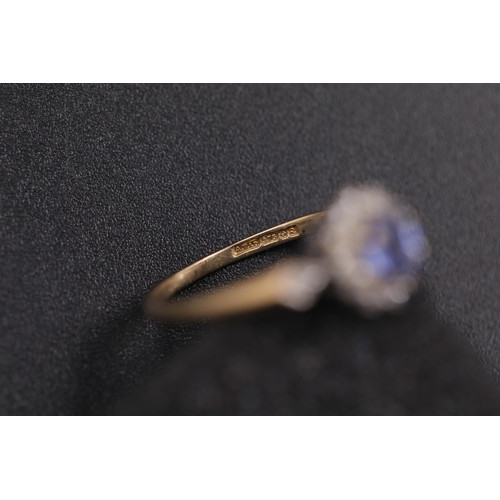 37 - Oval sapphire in diamond cluster set in 9ct yellow gold with diamond shoulders Ring size between N a... 