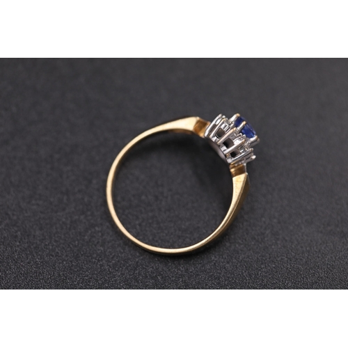 37 - Oval sapphire in diamond cluster set in 9ct yellow gold with diamond shoulders Ring size between N a... 