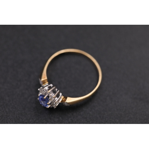 37 - Oval sapphire in diamond cluster set in 9ct yellow gold with diamond shoulders Ring size between N a... 