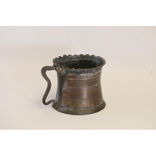 18 - An antique Middle Eastern bath pitcher made of bronze or copper, featuring a flared base, a wavy top... 