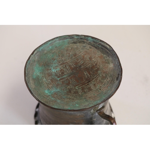 18 - An antique Middle Eastern bath pitcher made of bronze or copper, featuring a flared base, a wavy top... 