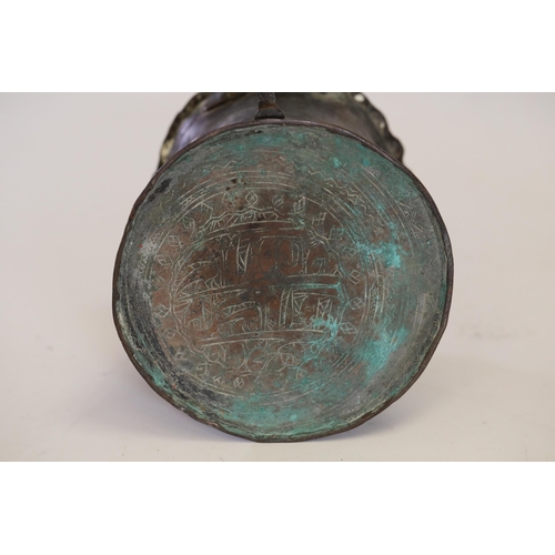 18 - An antique Middle Eastern bath pitcher made of bronze or copper, featuring a flared base, a wavy top... 