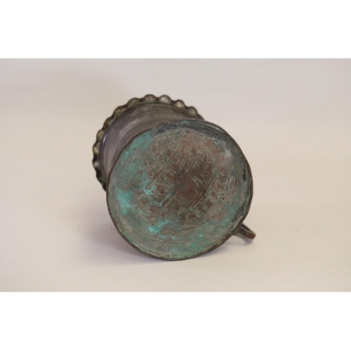 18 - An antique Middle Eastern bath pitcher made of bronze or copper, featuring a flared base, a wavy top... 